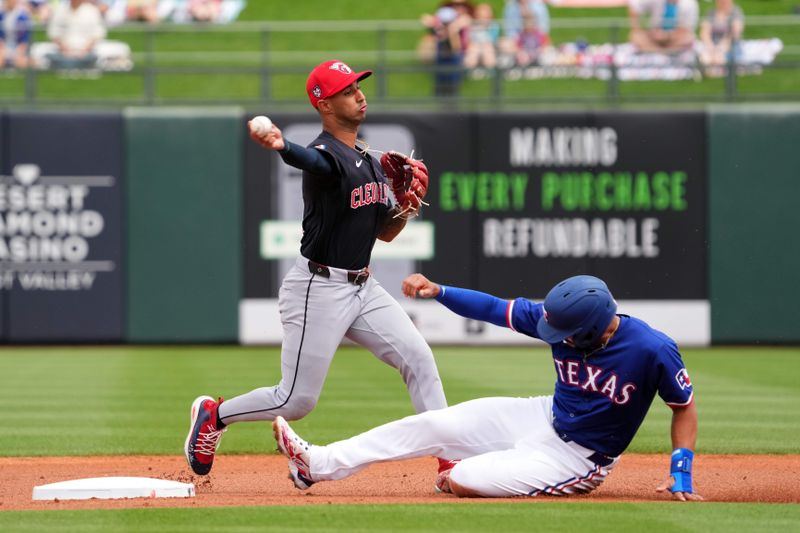 Mar 12, 2024; Surprise, Arizona, USA; Cleveland Guardians shortstop Brayan Rocchio (4) throws to first base after forcing out Texas Rangers second baseman Marcus Semien (2) at second base during the first inning at Surprise Stadium. Mandatory Credit: Joe Camporeale-USA TODAY Sports