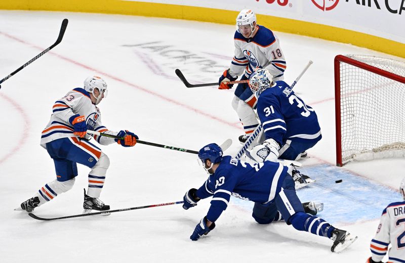 Mar 23, 2024; Toronto, Ontario, CAN; Edmonton Oilers forward Ryan Nugent-Hopkins (93) takes a shot that hits a post behind Toronto Maple Leafs goalie Martin Jones (31) in the third period at Scotiabank Arena. Mandatory Credit: Dan Hamilton-USA TODAY Sports