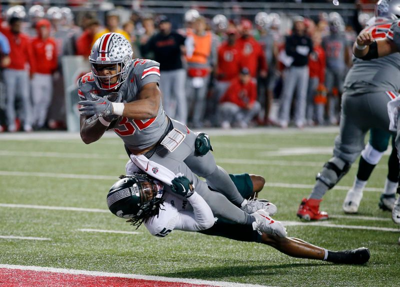 Nov 11, 2023; Columbus, Ohio, USA; Ohio State Buckeyes running back TreVeyon Henderson (32) scores a touchdown as Michigan State Spartans linebacker Jordan Hall (5) makes the tackle during the second quarter at Ohio Stadium. Mandatory Credit: Joseph Maiorana-USA TODAY Sports