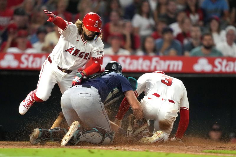 Aug 31, 2024; Anaheim, California, USA; Los Angeles Angels left fielder Taylor Ward (3) is tagged out at home plate by Seattle Mariners catcher Cal Raleigh (29) on a bunt attempt by Angels shortstop Jack Lopez (10) in the eighth inning at Angel Stadium. Mandatory Credit: Kirby Lee-USA TODAY Sports