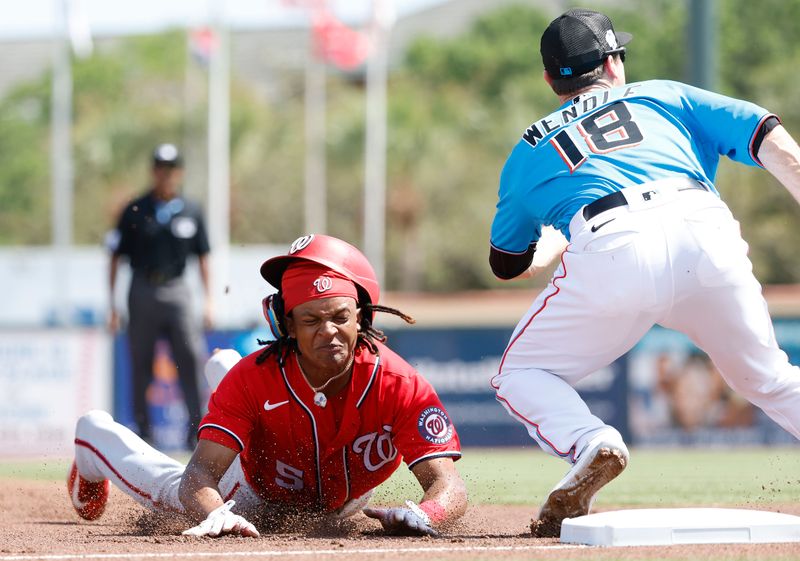 Mar 7, 2023; Jupiter, Florida, USA; Washington Nationals short stop CJ Abrams (5) slides into third base against Miami Marlins third baseman Joey Wendle (18) in the first inning at Roger Dean Stadium. Mandatory Credit: Rhona Wise-USA TODAY Sports