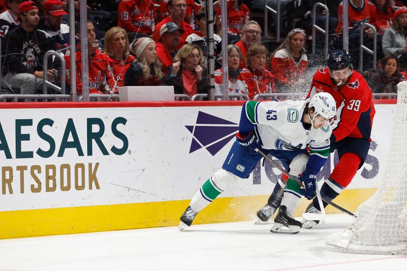 Feb 11, 2024; Washington, District of Columbia, USA; Vancouver Canucks defenseman Quinn Hughes (43) and Washington Capitals right wing Anthony Mantha (39) battles for the puck in the first period at Capital One Arena. Mandatory Credit: Geoff Burke-USA TODAY Sports