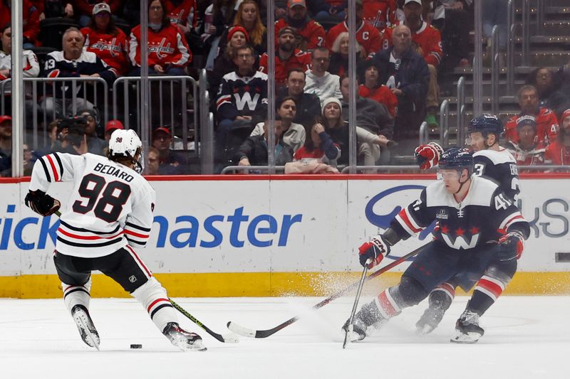 Mar 9, 2024; Washington, District of Columbia, USA; Chicago Blackhawks center Connor Bedard (98) skates with the puck as Washington Capitals left wing Beck Malenstyn (47) and Capitals defenseman Nick Jensen (3) defend in the third period at Capital One Arena. Mandatory Credit: Geoff Burke-USA TODAY Sports