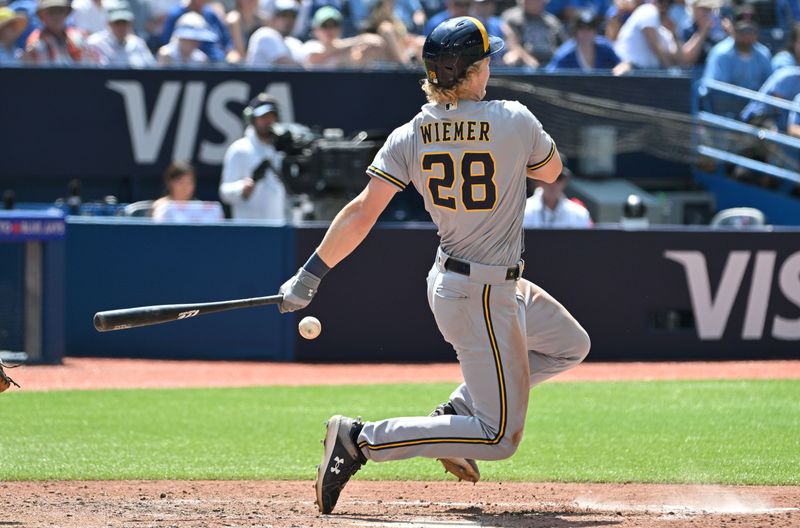 Jun 1, 2023; Toronto, Ontario, CAN; Milwaukee Brewers center fielder Joey Wiemer (28) loses his balance after fouling a ball off of his left foot in the eighth inning against the Toronto Blue Jays at Rogers Centre. Mandatory Credit: Dan Hamilton-USA TODAY Sports