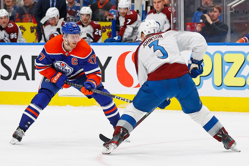 Mar 16, 2024; Edmonton, Alberta, CAN; Edmonton Oilers forward Connor McDavid (97) tries to move the puck past Colorado Avalanche defensemen Jack Johnson (3) during the third period at Rogers Place. Mandatory Credit: Perry Nelson-USA TODAY Sports