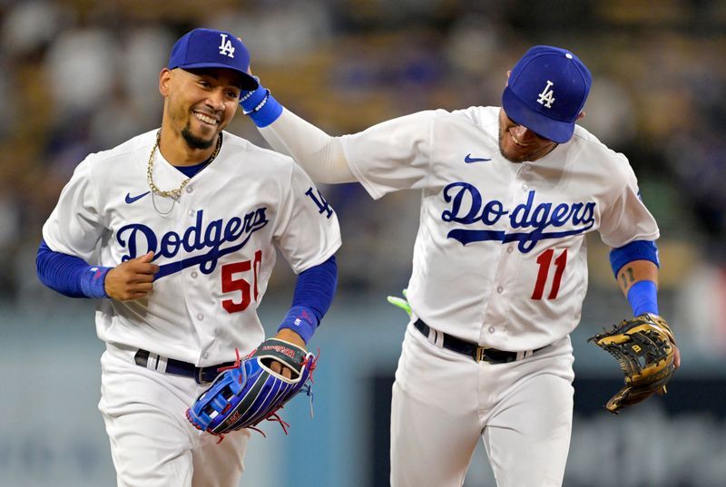 Aug 16, 2023; Los Angeles, California, USA;  Los Angeles Dodgers right fielder Mookie Betts (50) gets a pat from Los Angeles Dodgers shortstop Miguel Rojas (11) after the final out of the fifth inning against the Milwaukee Brewers at Dodger Stadium. Mandatory Credit: Jayne Kamin-Oncea-USA TODAY Sports