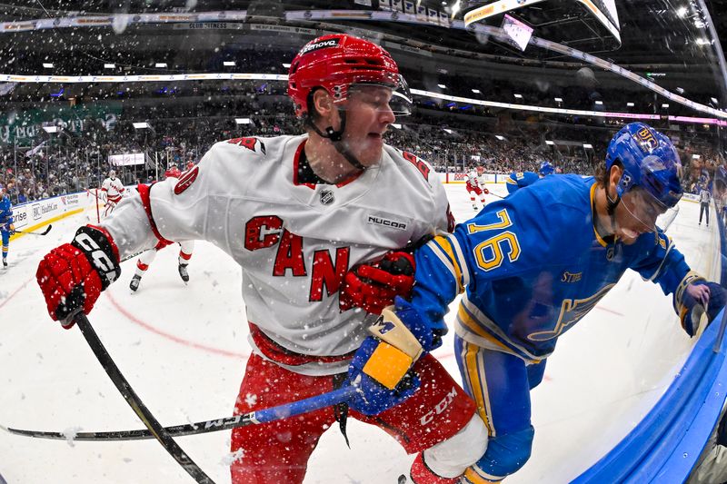 Oct 19, 2024; St. Louis, Missouri, USA;  Carolina Hurricanes left wing Eric Robinson (50) checks St. Louis Blues center Zack Bolduc (76) during the second period at Enterprise Center. Mandatory Credit: Jeff Curry-Imagn Images