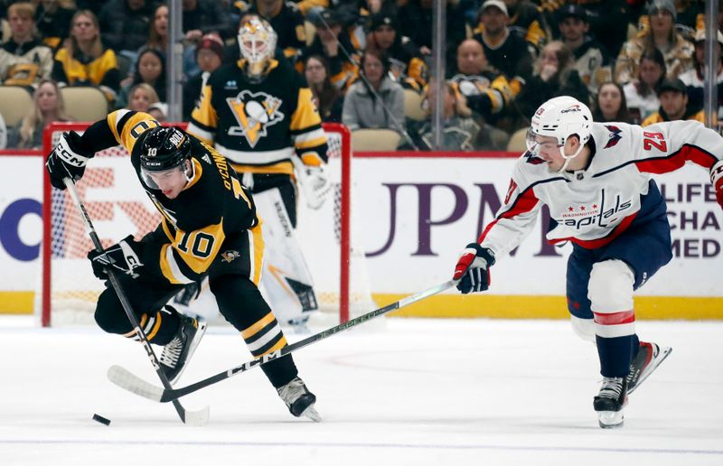 Jan 2, 2024; Pittsburgh, Pennsylvania, USA;  Pittsburgh Penguins left wing Drew O'Connor (10) moves the puck against Washington Capitals center Hendrix Lapierre (29)  during the first period at PPG Paints Arena. Mandatory Credit: Charles LeClaire-USA TODAY Sports