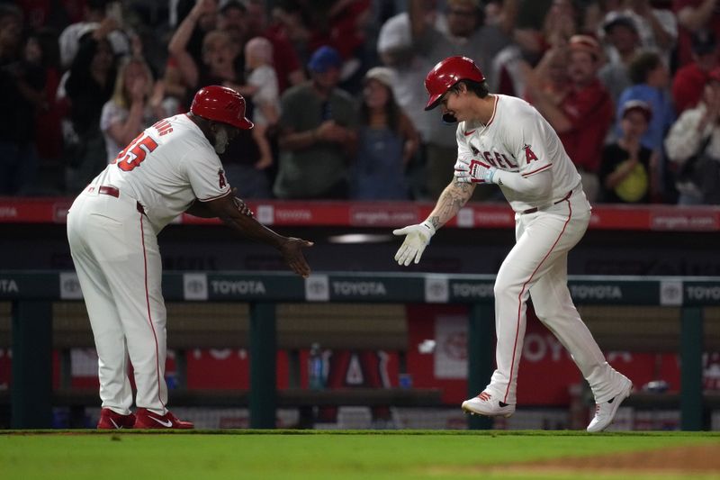 Aug 31, 2024; Anaheim, California, USA; Los Angeles Angels center fielder Mickey Moniak (16) is congratulated by third base coach Eric Young Sr. (85) after hitting a  walk-off home run in the ninth inning against the Seattle Mariners at Angel Stadium. Mandatory Credit: Kirby Lee-USA TODAY Sports