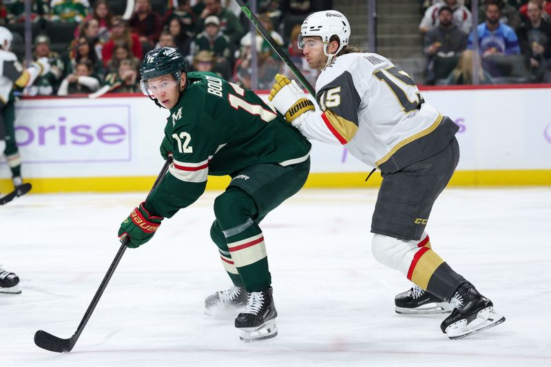 Nov 16, 2025; Saint Paul, Minnesota, USA; Minnesota Wild left wing Matt Boldy (12) and Vegas Golden Knights defenseman Noah Hanifin (15) compete for the puck during the second period at Grand Casino Arena. Mandatory Credit: Matt Krohn-Imagn Images