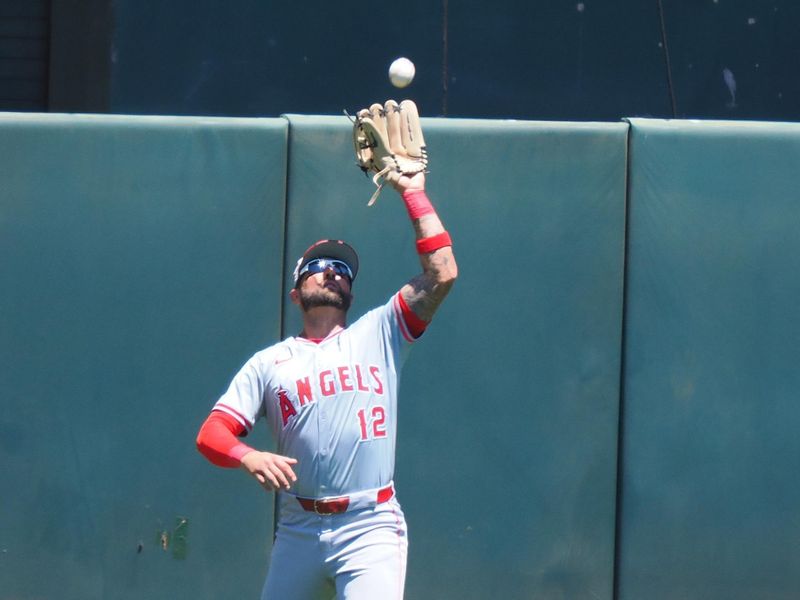 Jul 4, 2024; Oakland, California, USA; Los Angeles Angels center fielder Kevin Pillar (12) catches the ball against the Oakland Athletics during the third inning at Oakland-Alameda County Coliseum. Mandatory Credit: Kelley L Cox-USA TODAY Sports