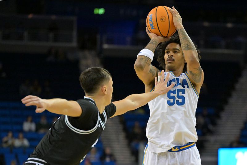 Dec 19, 2025; Los Angeles, California, USA; UCLA Bruins guard Skyy Clark (55) is defended by Cal Poly Mustangs guard Peter Bandelj (9) as he shoots a 3-point basket during the first half at Pauley Pavilion presented by Wescom Financial. Mandatory Credit: Jayne Kamin-Oncea-Imagn Images
