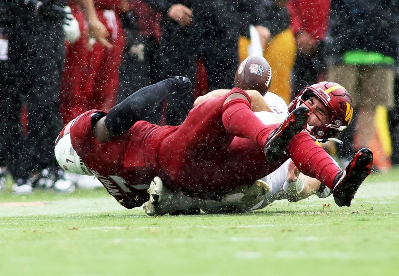 Arizona Cardinals linebacker Kyzir White (7) lays a hard hit on Washington Commanders quarterback Sam Howell (14)during an NFL football game, Sunday, September 10, 2023 in Landover, Maryland. (AP Photo/Daniel Kucin Jr.)