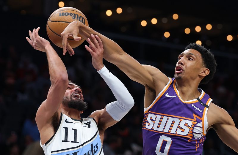 ATLANTA, GEORGIA - JANUARY 14:  Ryan Dunn #0 of the Phoenix Suns blocks a shot by Trae Young #11 of the Atlanta Hawks during the first quarter at State Farm Arena on January 14, 2025 in Atlanta, Georgia.  NOTE TO USER: User expressly acknowledges and agrees that, by downloading and/or using this photograph, user is consenting to the terms and conditions of the Getty Images License Agreement.  (Photo by Kevin C. Cox/Getty Images)