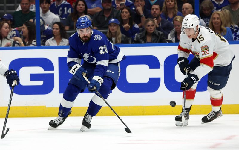 Apr 27, 2024; Tampa, Florida, USA;Tampa Bay Lightning left wing Nicholas Paul (20) skates with he puck as Florida Panthers center Anton Lundell (15) defends  during the first period in game four of the first round of the 2024 Stanley Cup Playoffs at Amalie Arena. Mandatory Credit: Kim Klement Neitzel-USA TODAY Sports