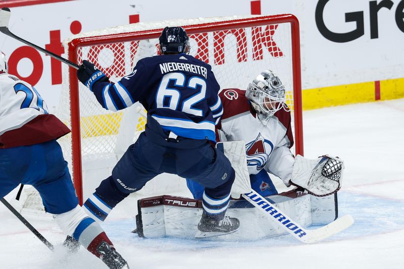 Apr 23, 2024; Winnipeg, Manitoba, CAN; Colorado Avalanche goalie Alexander Georgiev (40) covers the puck from Winnipeg Jets forward Nino Niederreiter (62) during the third period in game two of the first round of the 2024 Stanley Cup Playoffs at Canada Life Centre. Mandatory Credit: Terrence Lee-USA TODAY Sports