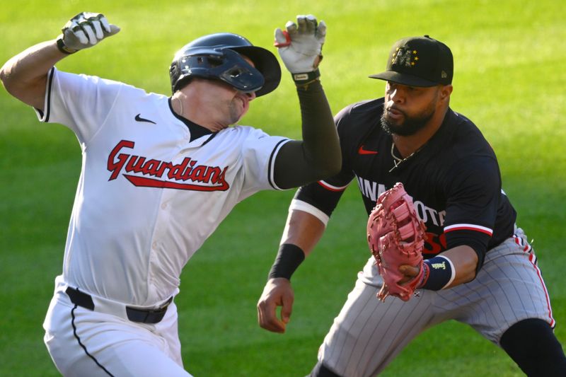 May 18, 2024; Cleveland, Ohio, USA; Minnesota Twins first baseman Carlos Santana (30) tags out Cleveland Guardians right fielder Will Brennan (17) in the third inning at Progressive Field. Mandatory Credit: David Richard-USA TODAY Sports