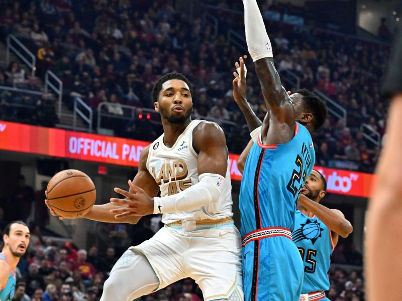 CLEVELAND, OHIO - JANUARY 04: Donovan Mitchell #45 of the Cleveland Cavaliers passes around Deandre Ayton #22 of the Phoenix Suns during the first half at Rocket Mortgage Fieldhouse on January 04, 2023 in Cleveland, Ohio. NOTE TO USER: User expressly acknowledges and agrees that, by downloading and or using this photograph, User is consenting to the terms and conditions of the Getty Images License Agreement. (Photo by Jason Miller/Getty Images)