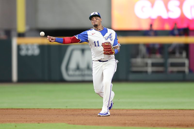 Apr 20, 2024; Cumberland, Georgia, USA;  Atlanta Braves shortstop Orlando Arcia (11) throws to first base against the Texas Rangers in the fifth inning at Truist Park. Mandatory Credit: Mady Mertens-USA TODAY Sports