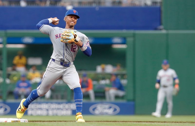 Jul 5, 2024; Pittsburgh, Pennsylvania, USA;  New York Mets shortstop Francisco Lindor (12) throws to first base to complete a double play against the Pittsburgh Pirates during the third inning at PNC Park. Mandatory Credit: Charles LeClaire-USA TODAY Sports