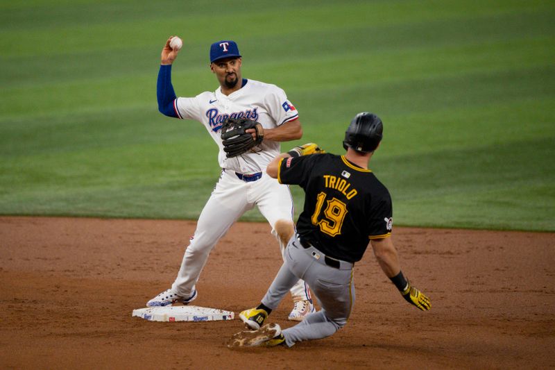 Aug 21, 2024; Arlington, Texas, USA; Texas Rangers second baseman Marcus Semien (2) puts out Pittsburgh Pirates third baseman Jared Triolo (19) as he turns a double play during the second inning at Globe Life Field. Mandatory Credit: Jerome Miron-USA TODAY Sports