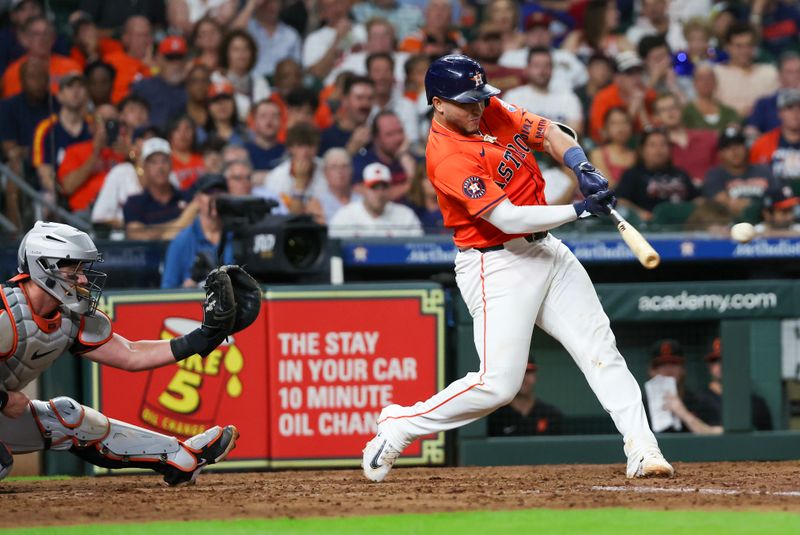 Jun 21, 2024; Houston, Texas, USA; Houston Astros catcher Yainer Diaz (21) hits a single against the Baltimore Orioles in the fifth inning at Minute Maid Park. Mandatory Credit: Thomas Shea-USA TODAY Sports