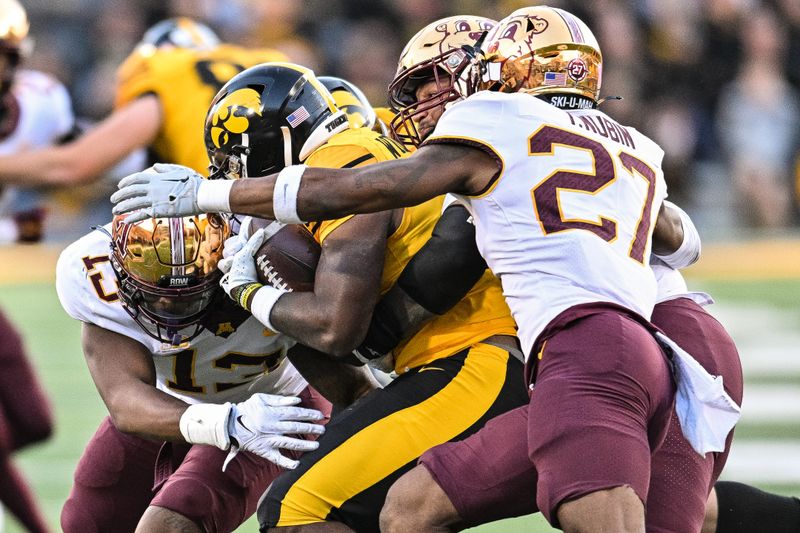 Oct 21, 2023; Iowa City, Iowa, USA; Iowa Hawkeyes running back Leshon Williams (4) is tackled by Minnesota Golden Gophers defensive back Tyler Nubin (27) and defensive lineman Deven Eastern (91) and defensive lineman Chris Collins (13) during the fourth quarter at Kinnick Stadium. Mandatory Credit: Jeffrey Becker-USA TODAY Sports