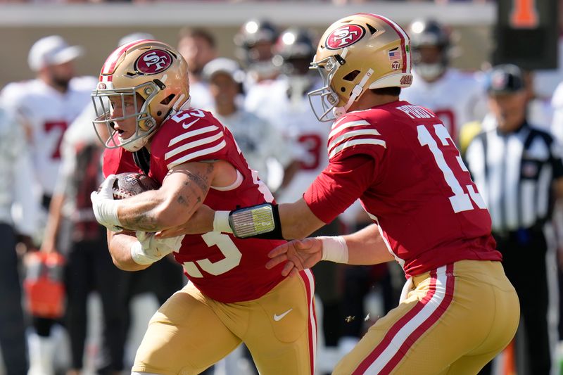 San Francisco 49ers quarterback Brock Purdy, right, hands the ball off to running back Christian McCaffrey during the first half of an NFL football game against the Tampa Bay Buccaneers in Tampa, Fla., Sunday, Nov. 10, 2024. (AP Photo/Chris O'Meara)