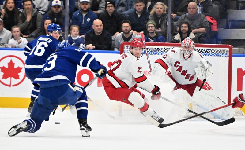 Dec 30, 2023; Toronto, Ontario, CAN; Carolina Hurricanes goalie Pyotr Kochetkov (52) and defenseman Brett Pesce (22) defend their goal against a shot from Toronto Maple Leafs forward Matthews Knies (23) in the second period at Scotiabank Arena. Mandatory Credit: Dan Hamilton-USA TODAY Sports