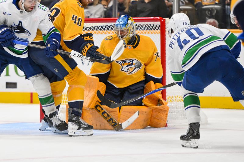 Oct 23, 2025; Nashville, Tennessee, USA;  Nashville Predators goaltender Juuse Saros (74) blocks the shot of Vancouver Canucks center Elias Pettersson (40) during the second period at Bridgestone Arena. Mandatory Credit: Steve Roberts-Imagn Images