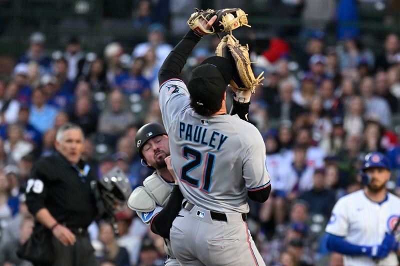 May 12, 2025; Chicago, Illinois, USA; Miami Marlins third base Graham Pauley (21) catches a fly ball in foul territory hit by Chicago Cubs outfielder Seiya Suzuki (27) as  catcher Liam Hicks (34) assists during the first inning at Wrigley Field. Mandatory Credit: Matt Marton-Imagn Images