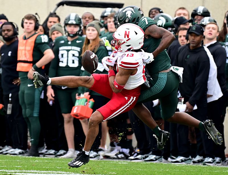 Nov 4, 2023; East Lansing, Michigan, USA;  Nebraska Cornhuskers defensive back Malcolm Hartzog (13) almost comes down with this pass intended for Michigan State Spartans wide receiver Antonio Gates Jr. (7) in the first quarter at Spartan Stadium. Mandatory Credit: Dale Young-USA TODAY Sports