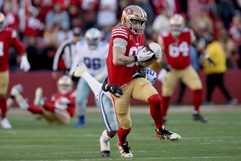 San Francisco 49ers tight end George Kittle (85) catches a pass in front of Dallas Cowboys cornerback DaRon Bland (26) during an NFL divisional round playoff football game, Sunday, Jan. 22, 2023, in Santa Clara, Calif. (AP Photo/Scot Tucker)