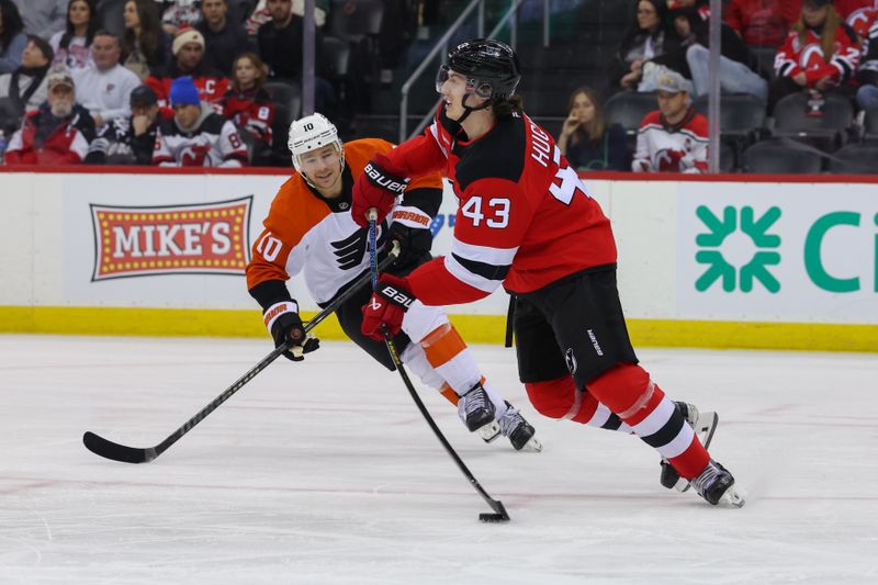 Jan 18, 2025; Newark, New Jersey, USA; New Jersey Devils defenseman Luke Hughes (43) passes the puck while being defended by Philadelphia Flyers right wing Bobby Brink (10) during the third period at Prudential Center. Mandatory Credit: Ed Mulholland-Imagn Images