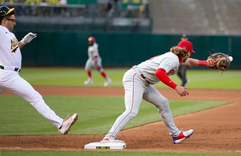 Jun 16, 2023; Oakland, California, USA; Philadelphia Phillies first baseman Alec Bohm (28) makes the catch to retire Oakland Athletics third baseman Jonah Bride (26) during the fourth inning at Oakland-Alameda County Coliseum. Mandatory Credit: D. Ross Cameron-USA TODAY Sports