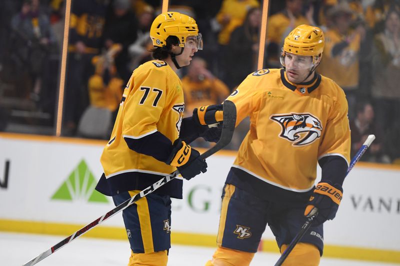 Jan 2, 2024; Nashville, Tennessee, USA; Nashville Predators right wing Luke Evangelista (77) is congratulated by defenseman Luke Schenn (2) after an empty-net goal during the third period against the Chicago Blackhawks at Bridgestone Arena. Mandatory Credit: Christopher Hanewinckel-USA TODAY Sports