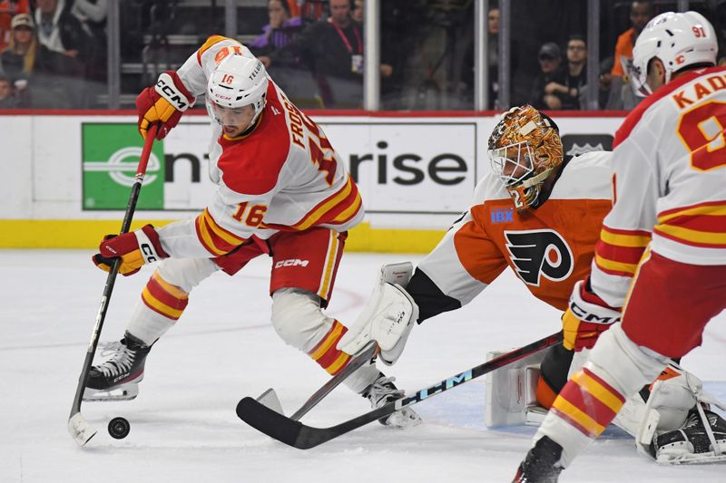 Mar 4, 2025; Philadelphia, Pennsylvania, USA; Calgary Flames center Morgan Frost (16) and Philadelphia Flyers goaltender Ivan Fedotov (82) battle for the puck during the second period at Wells Fargo Center. Mandatory Credit: Eric Hartline-Imagn Images