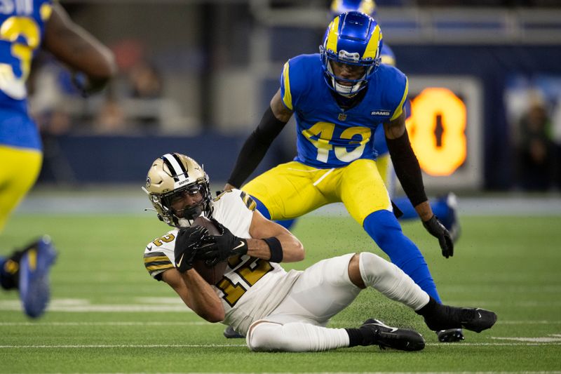 New Orleans Saints wide receiver Chris Olave (12) catches the ball in front of Los Angeles Rams safety John Johnson III (43) during an NFL football game, Thursday, Dec. 21, 2023, in Inglewood, Calif. (AP Photo/Kyusung Gong)