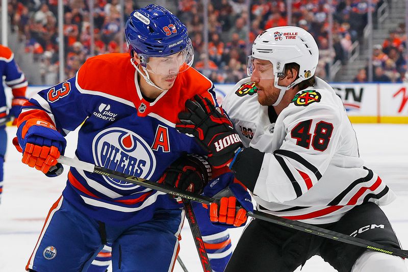 Nov 1, 2025; Edmonton, Alberta, CAN; Edmonton Oilers forward Ryan Nugent-Hopkins (93) and Chicago Blackhawks defensemen Matt Grzelcyk (48) battles for position during the third period at Rogers Place. Mandatory Credit: Perry Nelson-Imagn Images