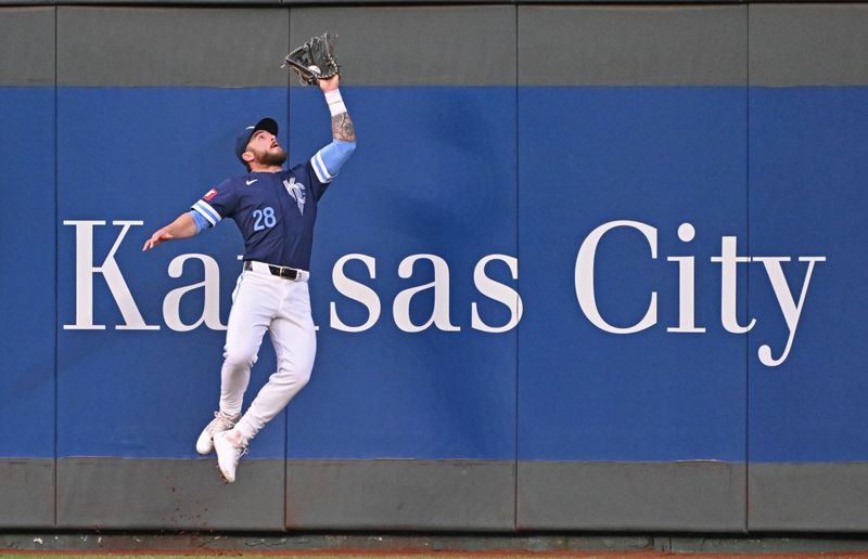Apr 19, 2024; Kansas City, Missouri, USA; Kansas City Royals center fielder Kyle Isbel (28) catches a fly ball at the wall in the fourth inning against the Baltimore Orioles at Kauffman Stadium. Mandatory Credit: Peter Aiken-USA TODAY Sports