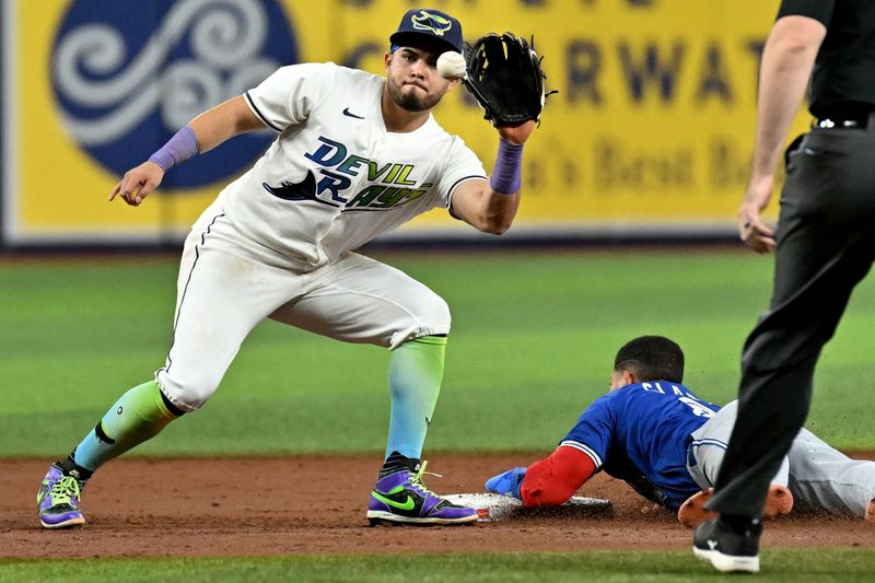 Sep 20, 2024; St. Petersburg, Florida, USA; Tampa Bay Rays second baseman Jonathan Aranda (62) waits for the ball as Toronto Blue Jays center fielder Jonatan Clase (8) slides in the third inning at Tropicana Field. Mandatory Credit: Jonathan Dyer-Imagn Images