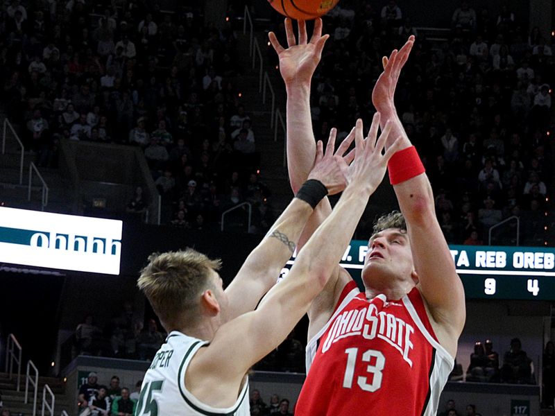 Feb 22, 2026; East Lansing, Michigan, USA;  Ohio State Buckeyes center Christoph Tilly (13) shoots over Michigan State Spartans center Carson Cooper (15) during the first half at Jack Breslin Student Events Center. Mandatory Credit: Dale Young-Imagn Images