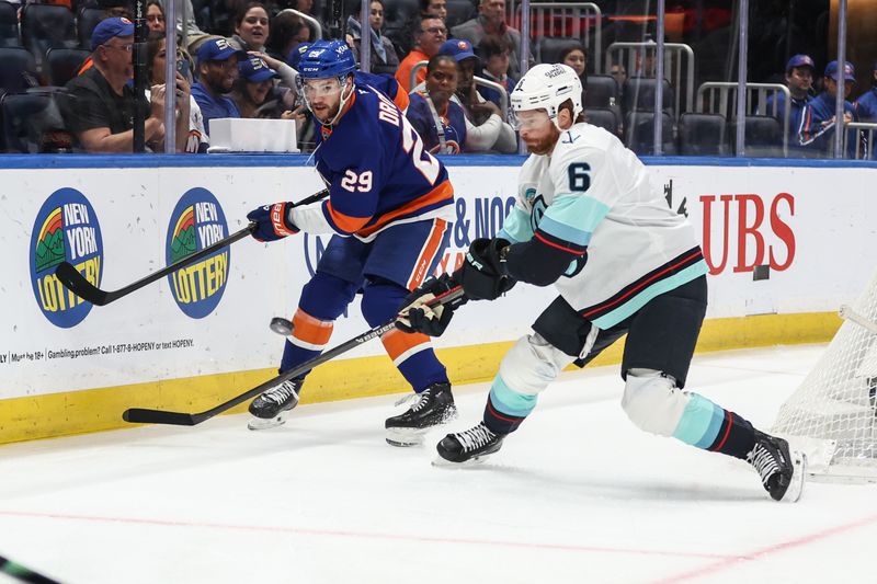 Nov 23, 2025; Elmont, New York, USA;  New York Islanders left wing Jonathan Drouin (29) and Seattle Kraken defenseman Adam Larsson (6) battle for control of the puck in the first period at UBS Arena. Mandatory Credit: Wendell Cruz-Imagn Images