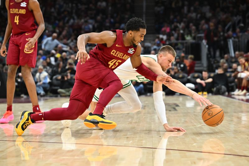 CLEVELAND, OHIO - DECEMBER 01: Donovan Mitchell #45 of the Cleveland Cavaliers and Kristaps Porzingis #8 of the Boston Celtics dive for a loose ball during the third quarter at Rocket Mortgage Fieldhouse on December 01, 2024 in Cleveland, Ohio. The Cavaliers defeated the Celtics 115-111. NOTE TO USER: User expressly acknowledges and agrees that, by downloading and or using this photograph, User is consenting to the terms and conditions of the Getty Images License Agreement. (Photo by Jason Miller/Getty Images)