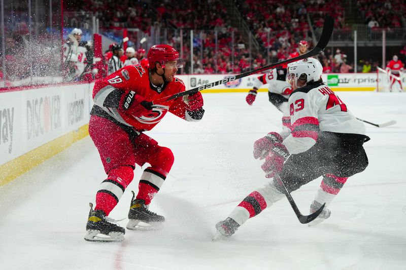 May 11, 2023; Raleigh, North Carolina, USA; Carolina Hurricanes center Jack Drury (18) passes the puck past New Jersey Devils defenseman Luke Hughes (43) during the first period in game five of the second round of the 2023 Stanley Cup Playoffs at PNC Arena. Mandatory Credit: James Guillory-USA TODAY Sports