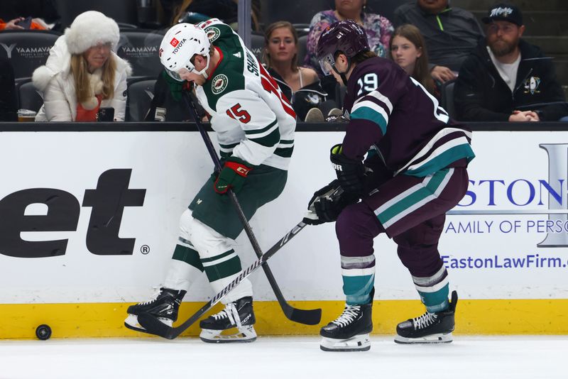 Mar 19, 2024; Anaheim, California, USA; Minnesota Wild center Mason Shaw (15) kicks the puck against Anaheim Ducks right wing Troy Terry (19) during the first period of a game at Honda Center. Mandatory Credit: Jessica Alcheh-USA TODAY Sports