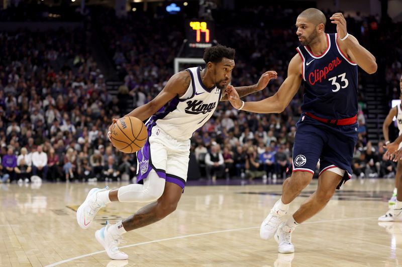 SACRAMENTO, CALIFORNIA - NOVEMBER 08: Malik Monk #0 of the Sacramento Kings is guarded by Nicolas Batum #33 of the LA Clippers in the second half at Golden 1 Center on November 08, 2024 in Sacramento, California. NOTE TO USER: User expressly acknowledges and agrees that, by downloading and/or using this photograph, user is consenting to the terms and conditions of the Getty Images License Agreement.  (Photo by Ezra Shaw/Getty Images)