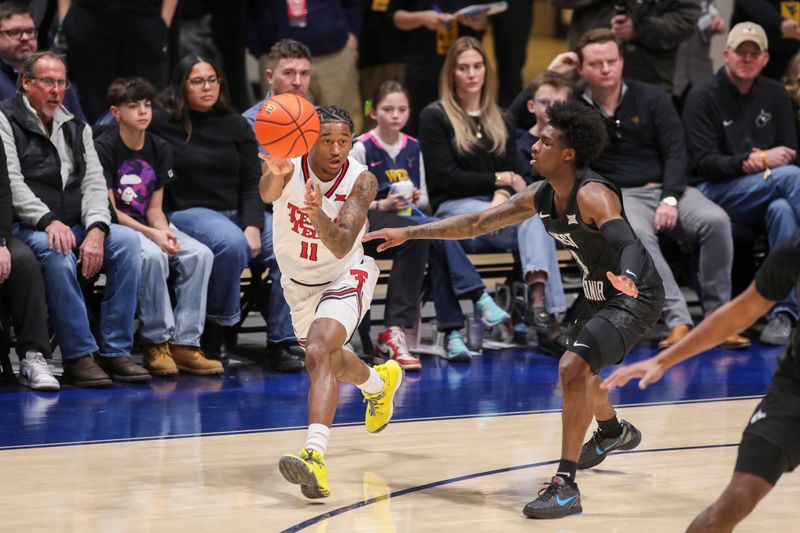 Feb 8, 2026; Morgantown, West Virginia, USA; Texas Tech Red Raiders guard Jaylen Petty (11) passes while defended by West Virginia Mountaineers guard Honor Huff (3) during the first half at Hope Coliseum. Mandatory Credit: Ben Queen-Imagn Images