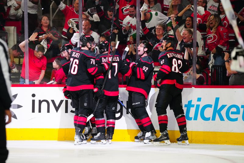 Apr 30, 2024; Raleigh, North Carolina, USA; Carolina Hurricanes right wing Stefan Noesen (23) is congratulated by center Evgeny Kuznetsov (92) defenseman Tony DeAngelo (77) and defenseman Brady Skjei (76) after his goal against the New York Islanders during the third period in game five of the first round of the 2024 Stanley Cup Playoffs at PNC Arena. Mandatory Credit: James Guillory-USA TODAY Sports