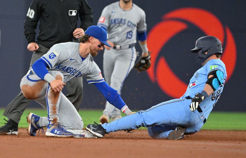 Apr 30, 2024; Toronto, Ontario, CAN;   Toronto Blue Jays left fielder Davis Schneider (36) is tagged out by Kansas City Royals shortstop Bobby Witt Jr. (7) trying to stretch a single into a double in the second inning at Rogers Centre. Mandatory Credit: Dan Hamilton-USA TODAY Sports